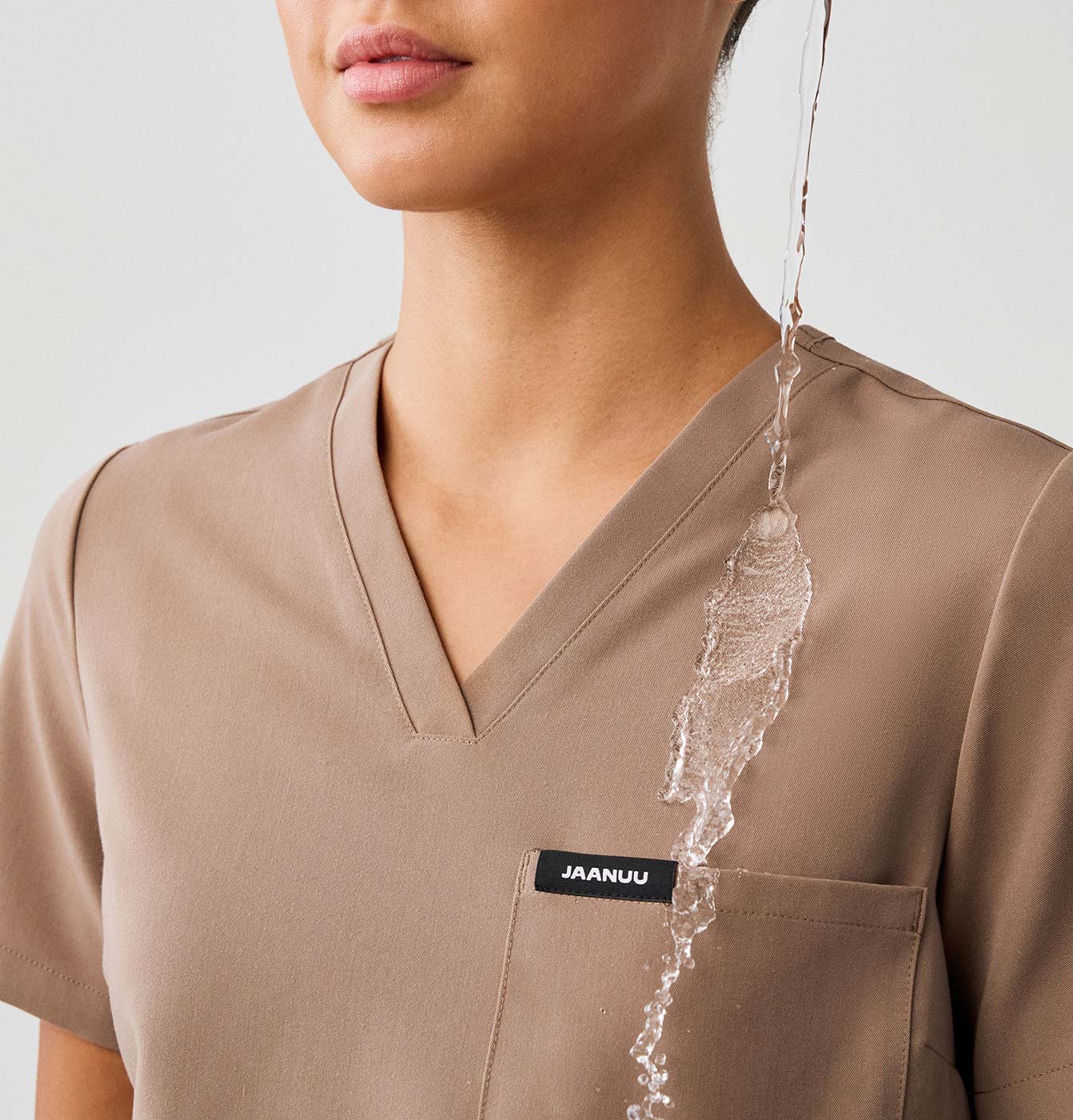 Water being poured on water-repellant finished scrubs.