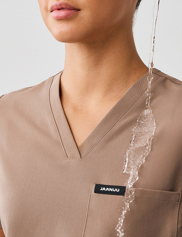 Water being poured on water-repellant finished scrubs.