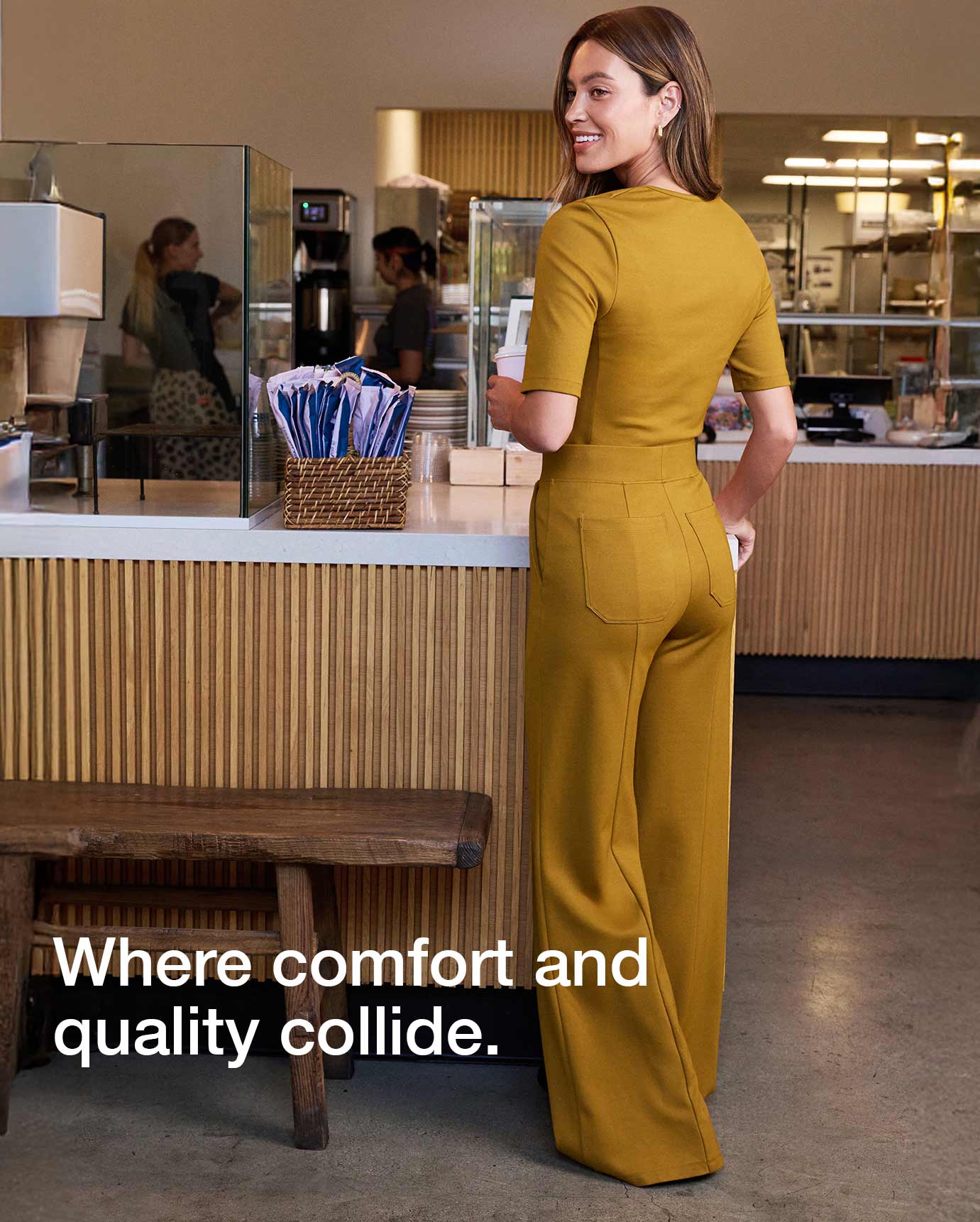 Image of a woman wearing Cider scrubs while holding a coffee. Image has text, "Where comfort and quality collide.".