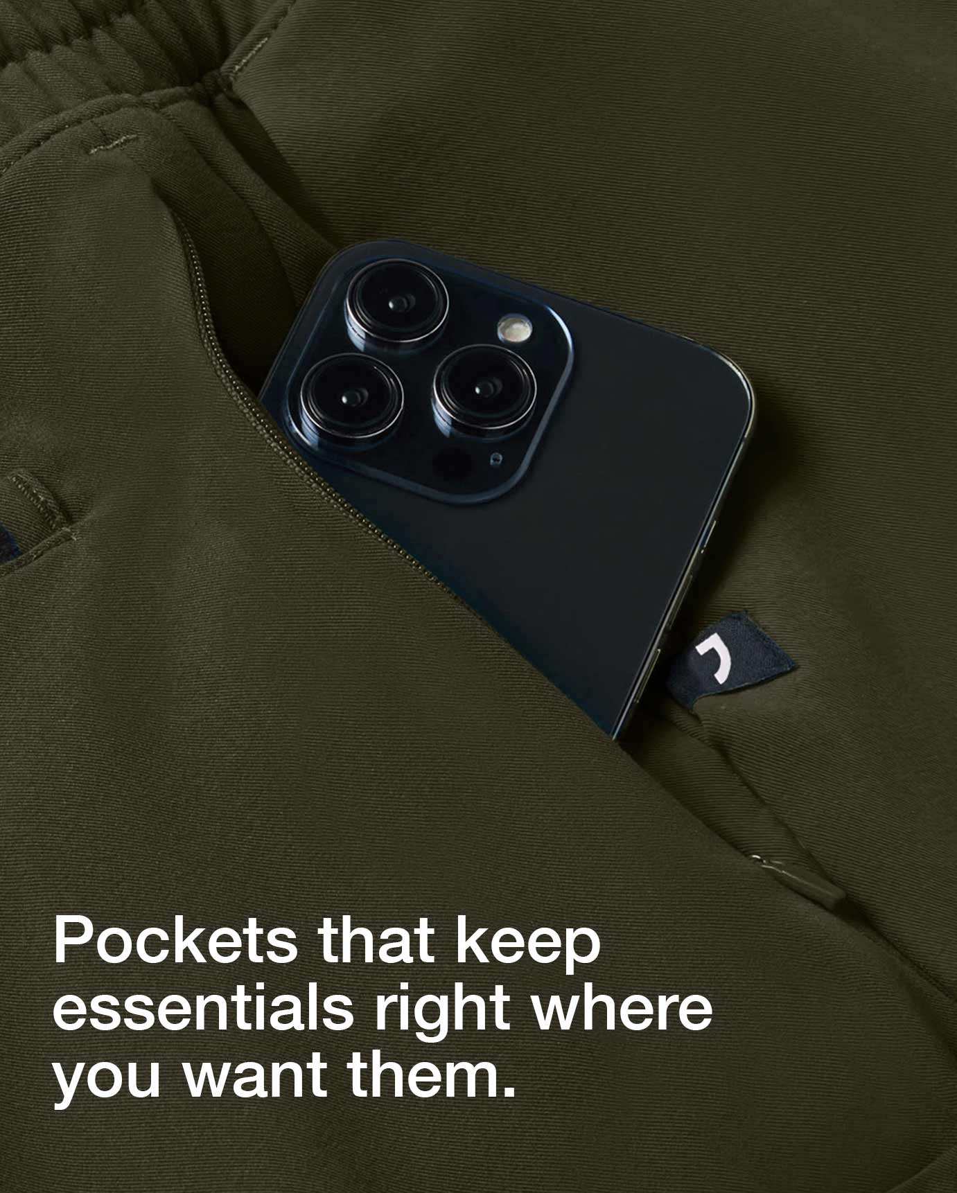 Closeup image of a pocket on a scrub garment. The pocket is holding a mobile phone. Image has text, "Pockets that keep essentials right where you want them.".