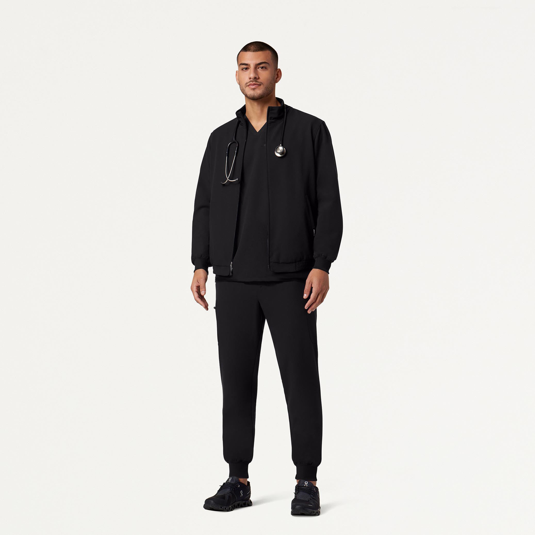 Man wearing black scrubs and black scrub jacket