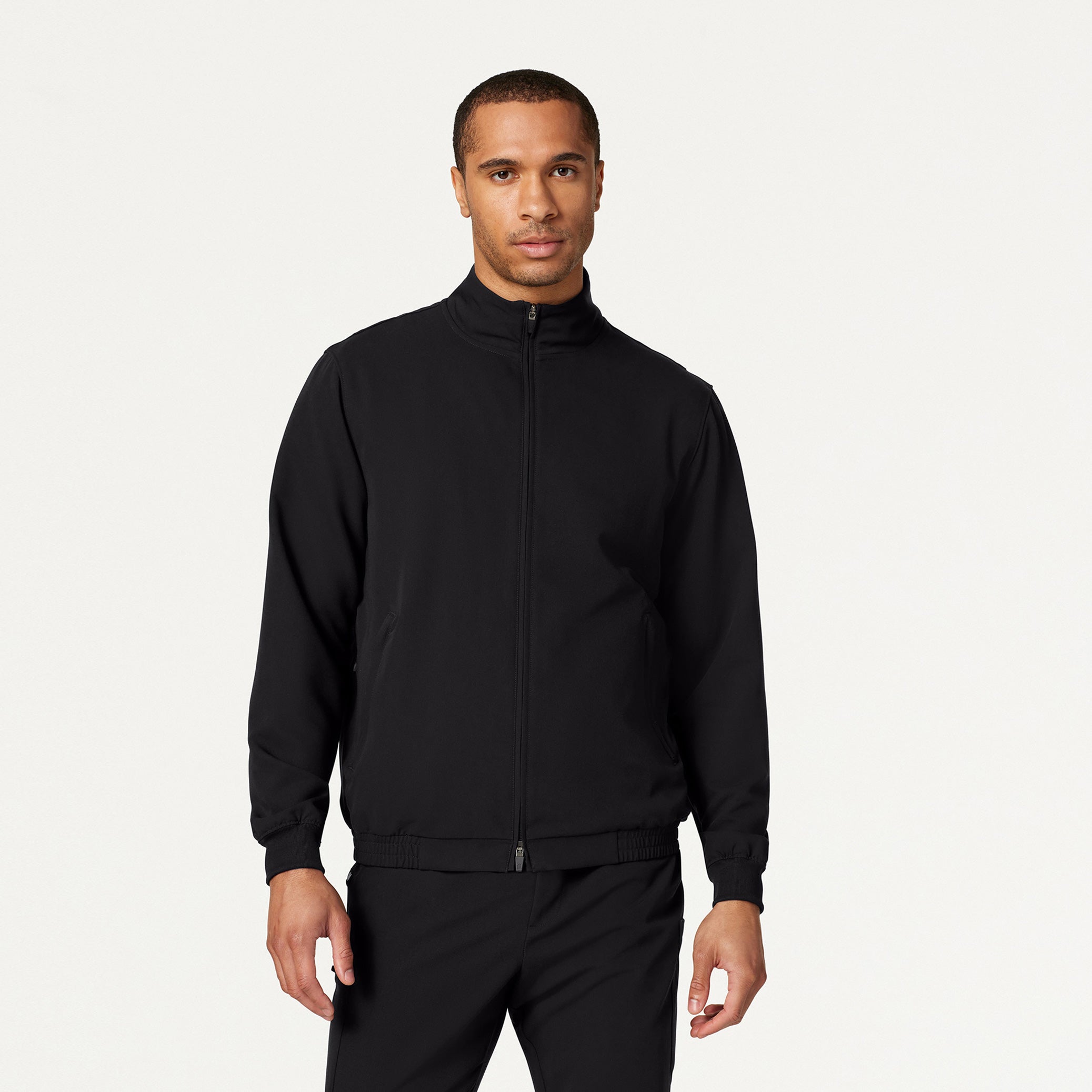 Man wearing black scrubs and black scrub jacket