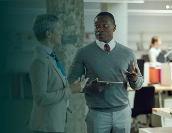 A man and a woman stand in an office setting.